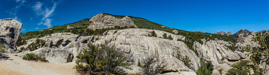 Low angle view of rocks against clear blue sky