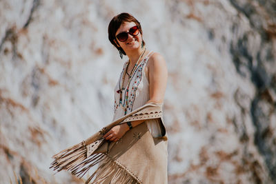 Young woman wearing sunglasses while standing outdoors