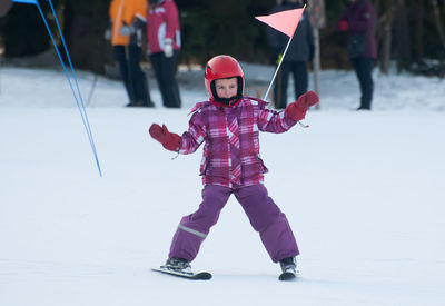 Girl skiing on snow covered field 