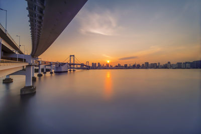 Scenic view of bridge over river against sky during sunset