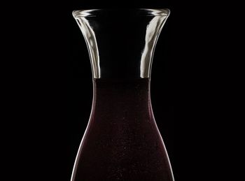 Close-up of glass bottle against black background