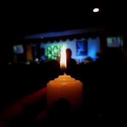 Close-up of illuminated candle in darkroom