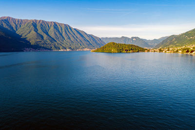 Scenic view of lake and mountains against blue sky