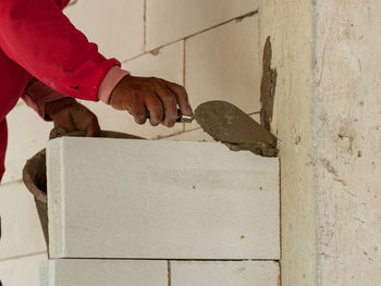 Man working on wood against wall