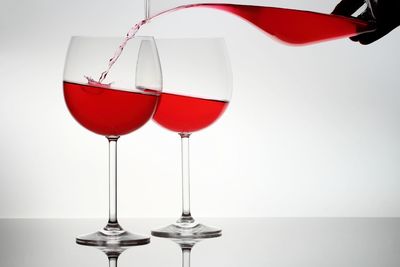 Close-up of wineglass on table against white background