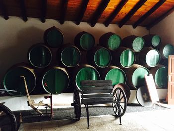 Empty chair against barrels indoors