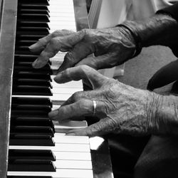 Midsection of man playing piano