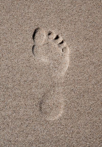 High angle view of footprints on sand at beach