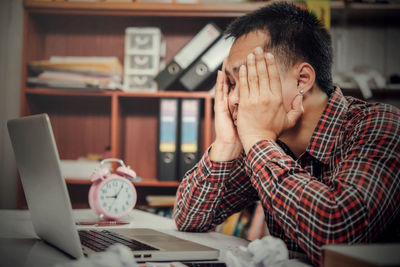 Midsection of man using mobile phone at table