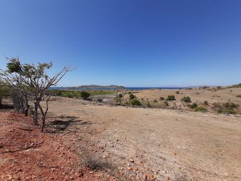 Scenic view of desert against clear blue sky