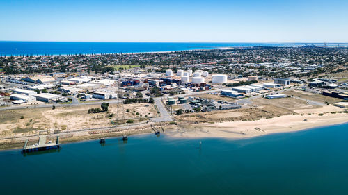 High angle view of townscape by sea against clear sky