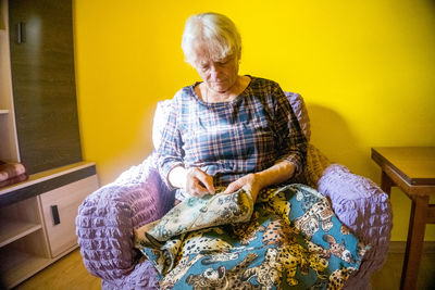 Rear view of woman sitting on sofa at home