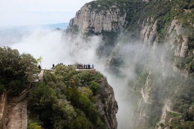 View of tourists at observation point on mountain in valley