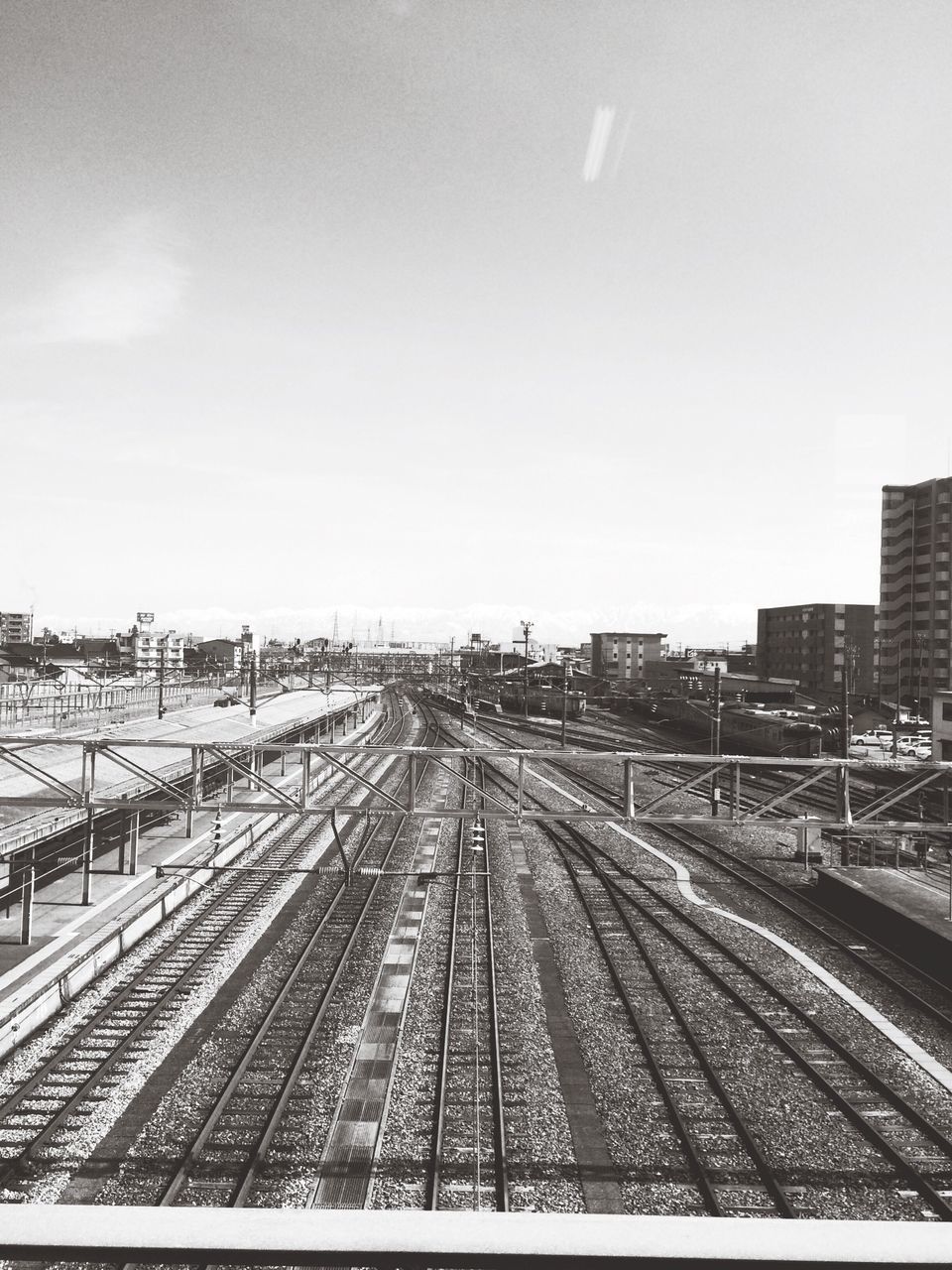 transportation, railroad track, rail transportation, public transportation, the way forward, railroad station platform, railroad station, diminishing perspective, vanishing point, railway track, train - vehicle, sky, high angle view, mode of transport, travel, clear sky, built structure, connection, no people, journey