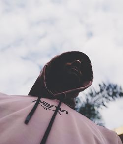 Low angle portrait of woman against sky