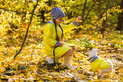 Rear view of boy with yellow umbrella in autumn