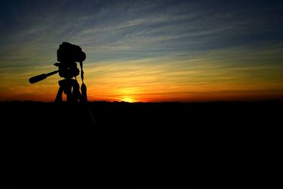 Silhouette of photographing at sunset