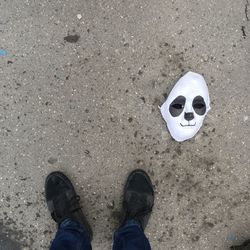 Low section of man standing by mask on road 