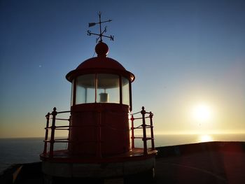 Lighthouse in sea against clear sky