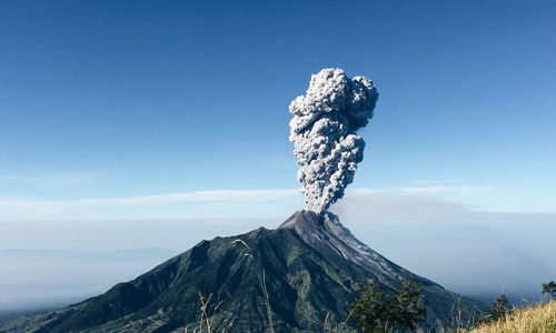 Smoke emitting from volcanic mountain against sky