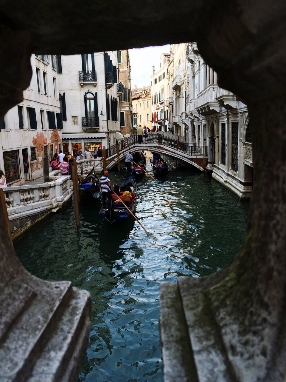 canal, architecture, travel destinations, travel, building exterior, gondola - traditional boat, cultures, built structure, tourism, vacations, water, large group of people, real people, outdoors, gondolier, day, people