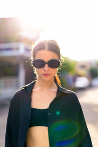 Portrait of young woman wearing sunglasses standing outdoors