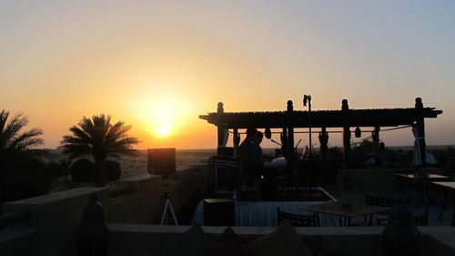 Silhouette built structure against clear sky during sunset