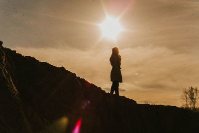 Silhouette man standing on mountain against sky during sunset