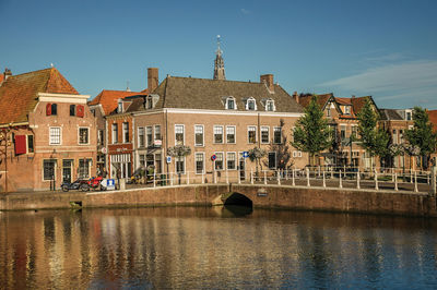 Arch bridge over river against buildings in city