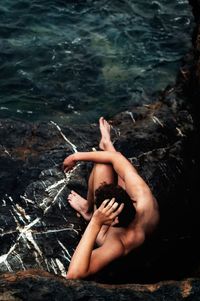 High angle view of shirtless man in sea