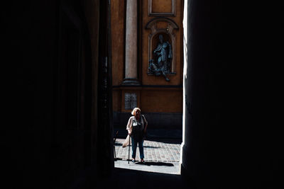 Rear view of man standing at entrance of building