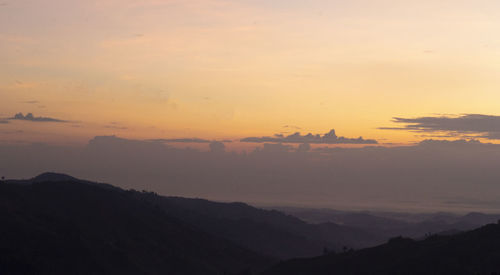 Scenic view of silhouette mountains against sky during sunset