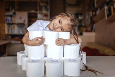 Girl holding ice cream on table at home