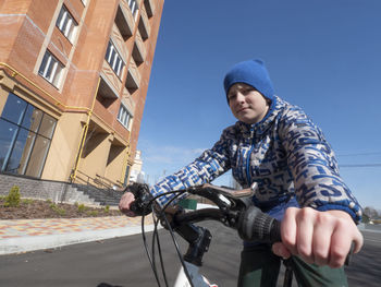 Low angle view of man riding bicycle against sky