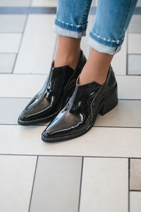 Low section of woman standing on tiled floor