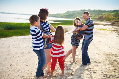 Rear view of friends standing on beach