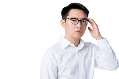 Portrait of young man standing against white background