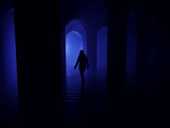 Silhouette woman walking in building with water