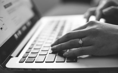 Cropped image of hands using laptop