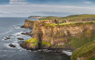 Panoramic shot of dunluce castle at sunset located on the edge of cliff, northern ireland