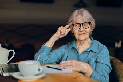 Smiling senior woman gesturing at cafe