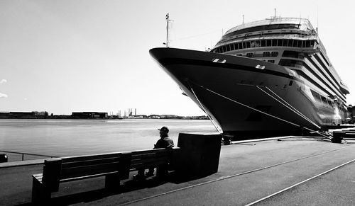 People at harbor against clear sky