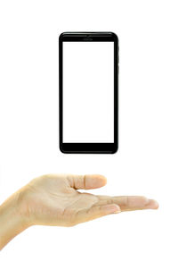 Close-up of hand using mobile phone against white background