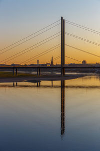 Bridge over river against sky during sunset