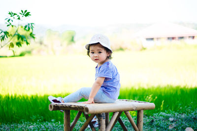 Cute boy sitting on field