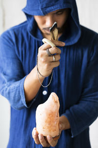 Man lighting a palo santo and hand holding himalaya salt stone. meditation concept