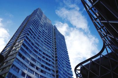 Low angle view of modern building against cloudy sky