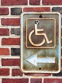 Full frame shot of arrow sign on brick wall