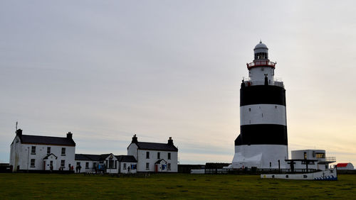 Lighthouse against sky at sunset