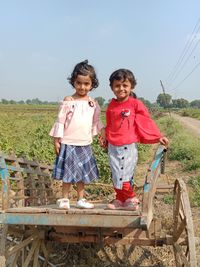 Portrait of a smiling girl standing against the sky